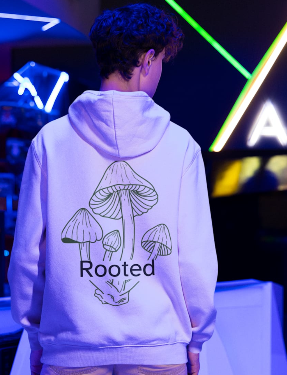 Person wearing a hoodie with a design and text in a neon-lit room